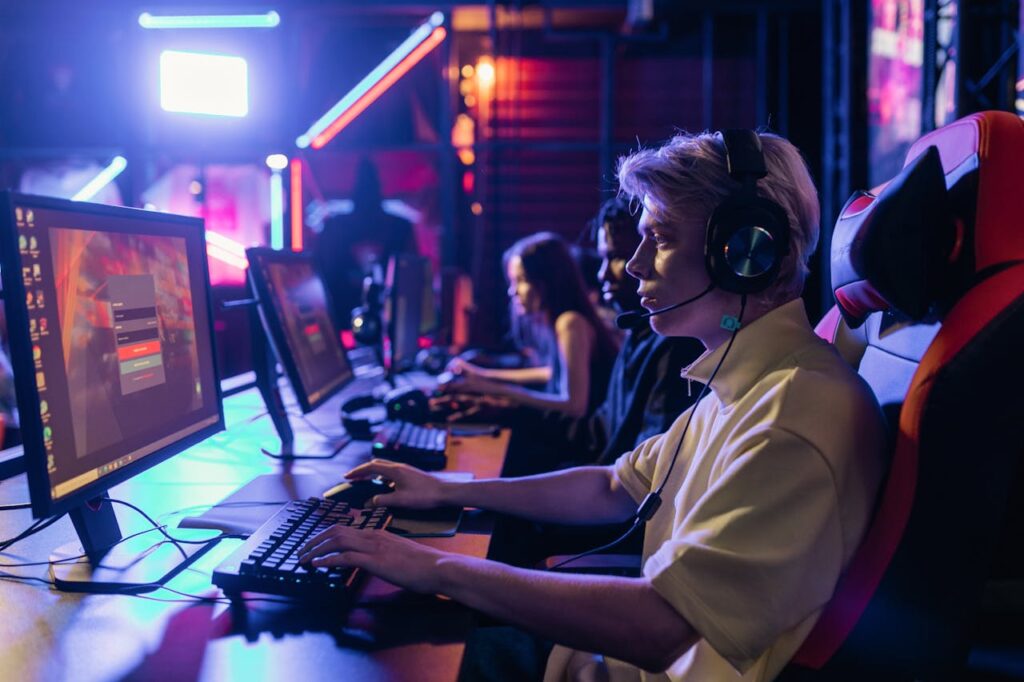 Gamers engaged in a competitive session, equipped with headsets and monitors in an immersive setup.