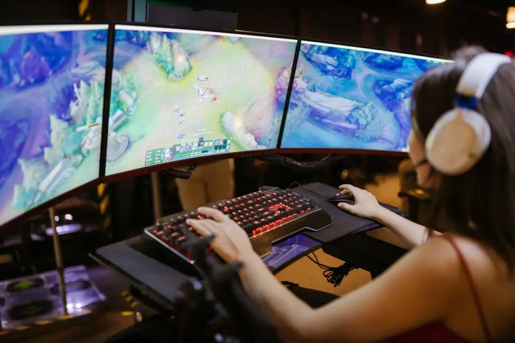 A young woman intently gaming on a multi-screen setup, showcasing vibrant gaming visuals.